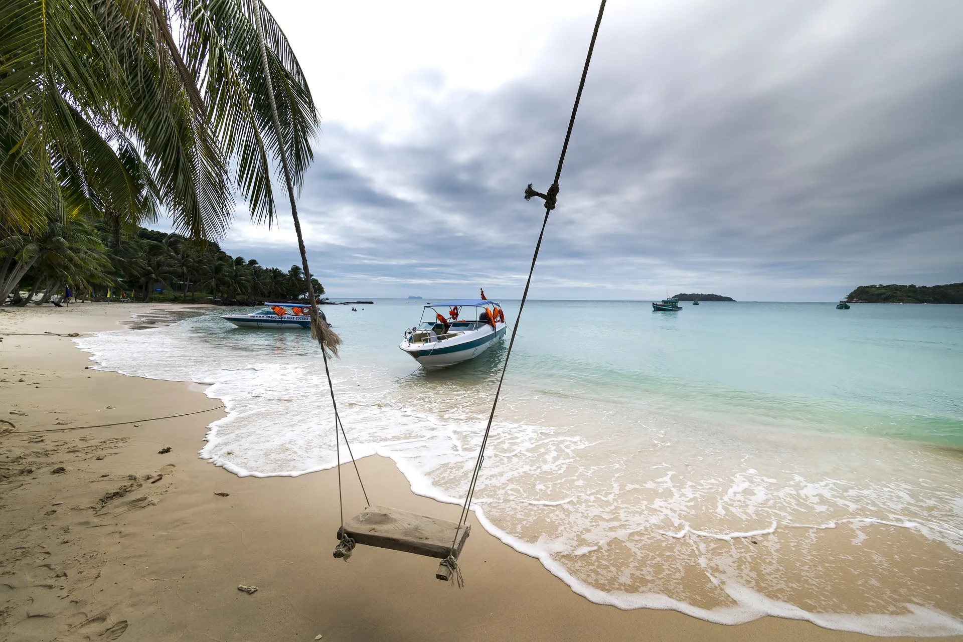 swing and boats on a beach in phu quoc