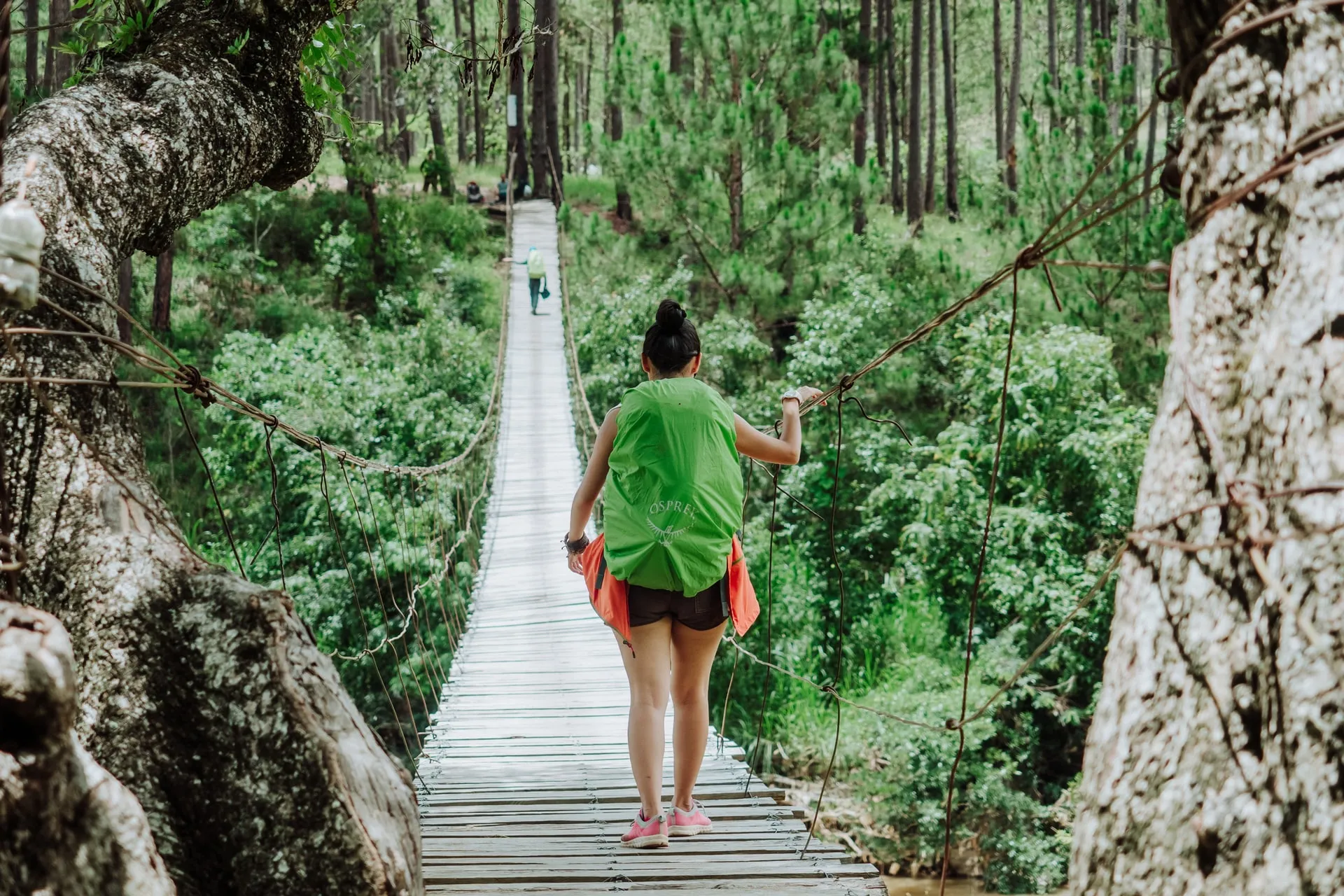 female solo traveler crossing a bridge in dalat