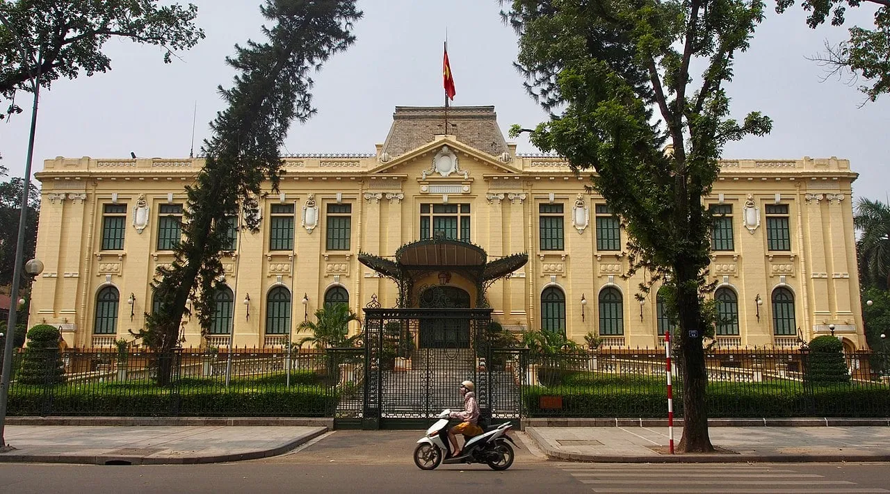 Exterior of state guest house in hanoi with a moped passing by