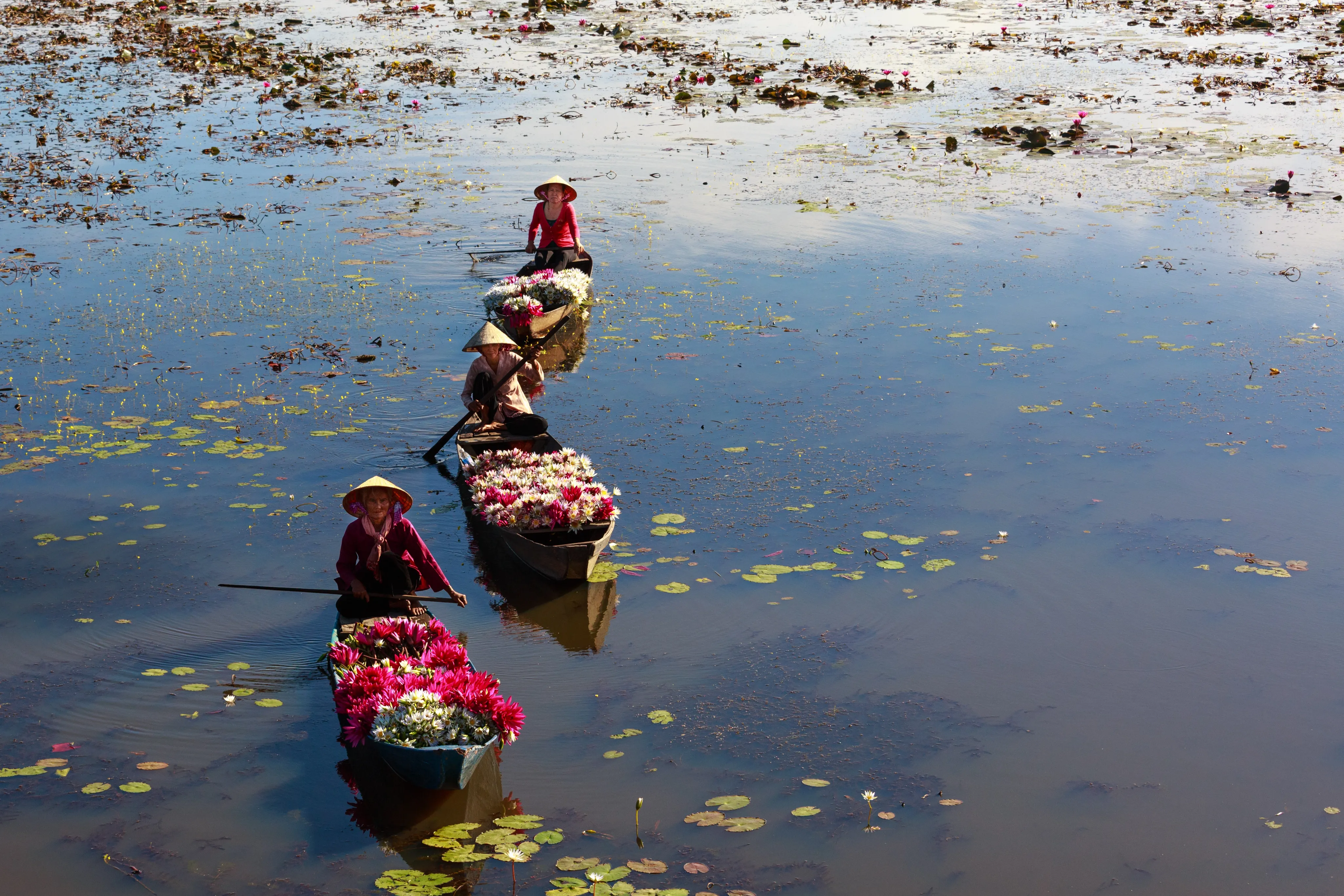 Women selling flowers in a floating market in Mekong Delta