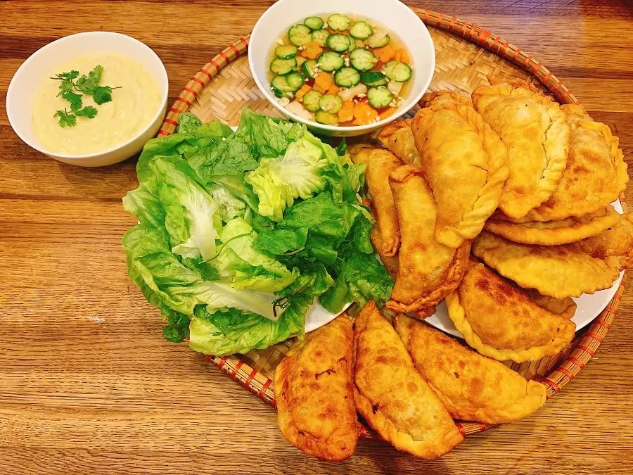 The cake is served with raw vegetables and sweet and sour dipping sauce
